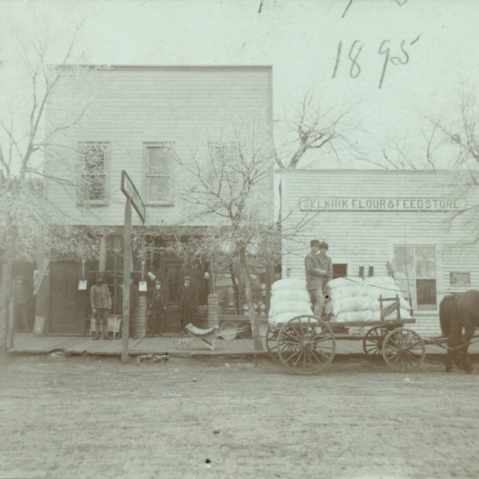 232 Manitoba Ave, 1895, Source Unknown Black and white photo of stores with a horse carriage in front