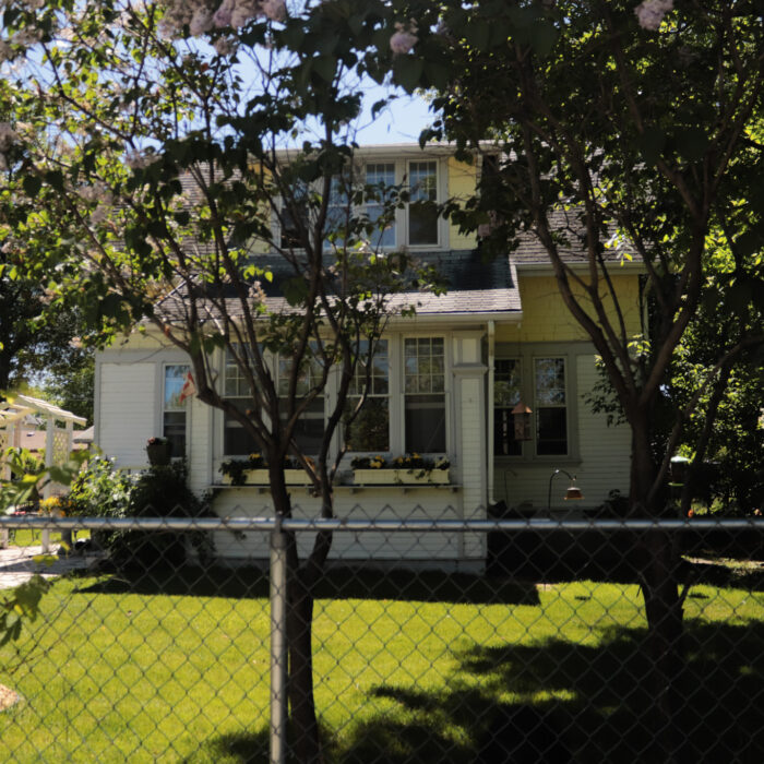 212 McLean Ave, 2020, Selkirk Museum Collection A colour image of a house and yard taken from the sidewalk. There is a chain link fence across the front of the property