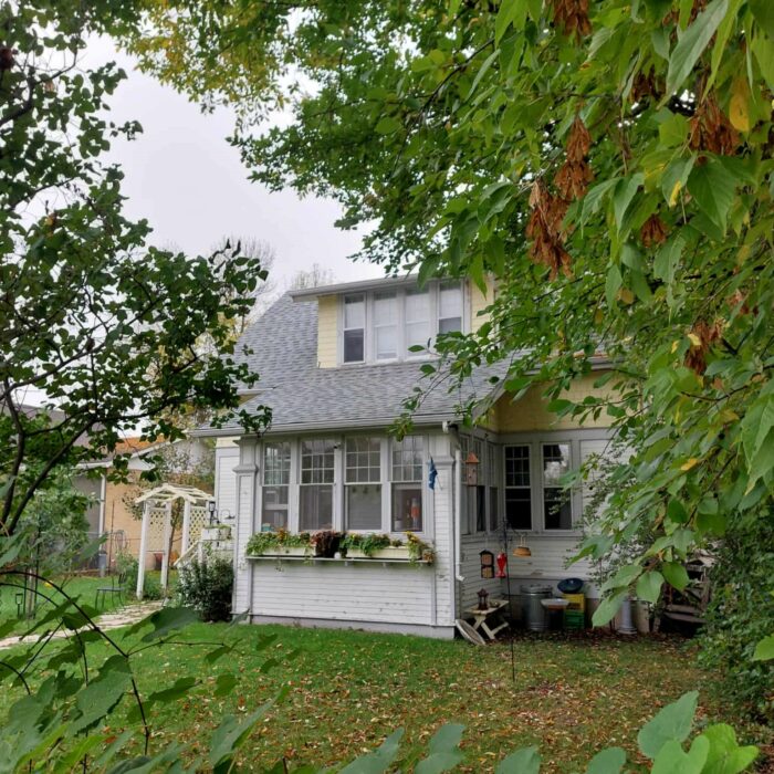 212 McLean Ave, 2025, Selkirk Museum Collection A colour image of a small cottage style house. There are lots of trees surrounding the house