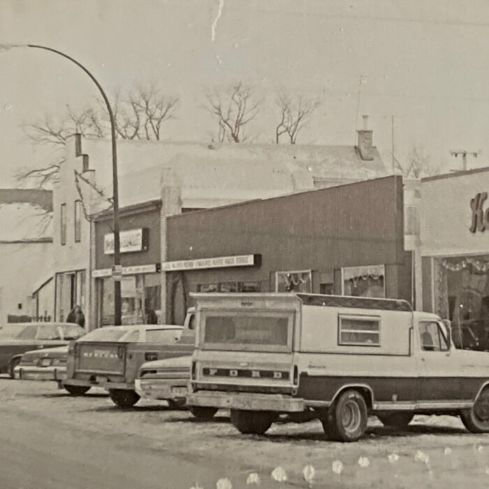 Manitoba Ave Looking South East from Main Street, View of 244 Manitoba Ave, 1975, Selkirk Enterprise Black and white photo of cars parked in front of stores on Manitoba Ave