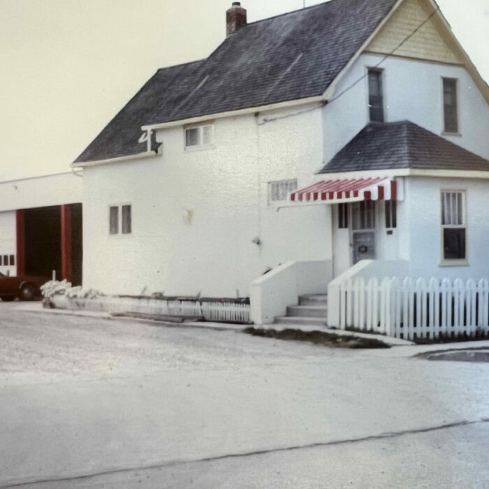 Colour photo of a white house with a grey roof