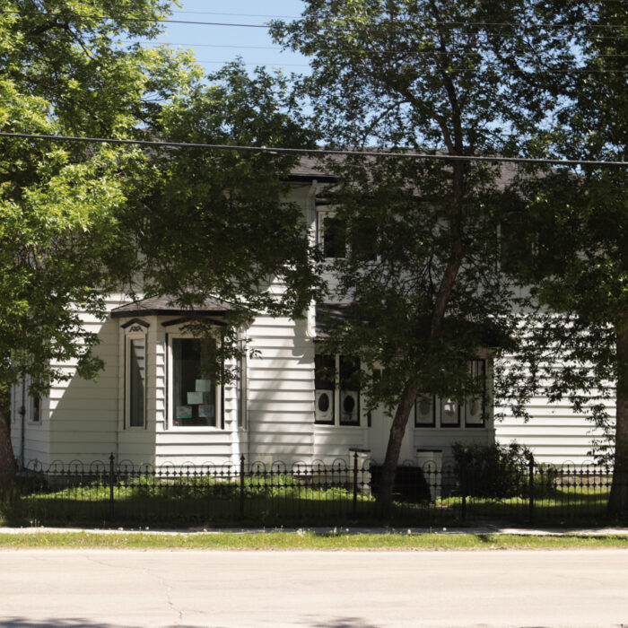 322 Eveline St, 2020, Selkirk Museum Collection Coloured photo of a white home fenced in on Eveline Street