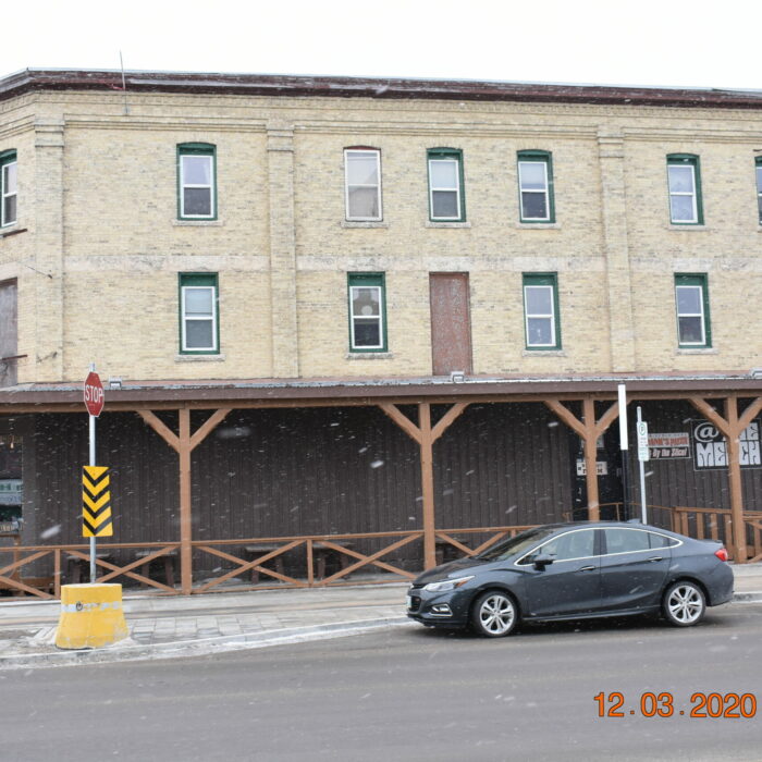 383 Eveline St, Merchant's Hotel, 2020, Peter Hall Colour photo of a large three-story building. The building is beige brick and has a wooden porch on the front