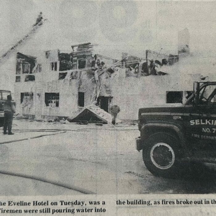 All that Remained of the Eveline Hotel Fire, 1970, Rob Scherza Fire Trucks in front of a burned building. There is a firetruck in the foreground of the image with the burned building in the background.