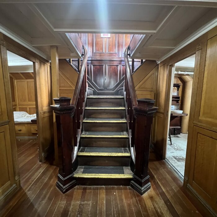C. G. S. Bradbury Staircase, 2026, Selkirk Museum Collection Colour photo of a wood paneled room with a staircase at the center of the image