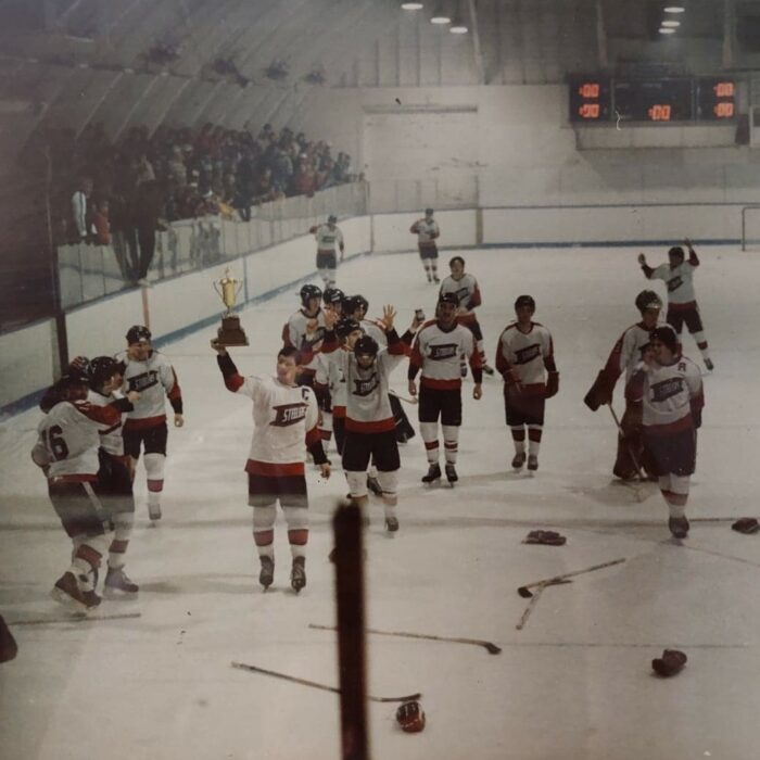 Championship Win, 1975, Source Unknown Hockey players skate around the ice holding up a trophy. Sticks and gloves are laying on the ice