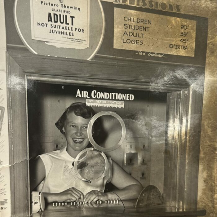 Black and white photo of a woman manning the ticket booth at the Garry theatre in the 1960s
