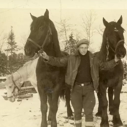 Dad, Jock, Age 14 Worked with Percheron Horses Fish Freighting. Six Years later he Signed up for WWII in 1939, 1933, Jock Langlois Man holding the reigns of two black horses