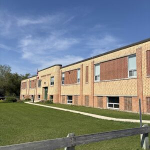 Colour photo of a brick school building. The building is two storeys tall