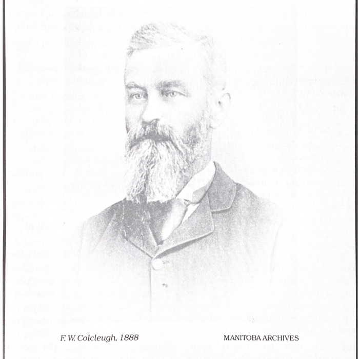 Black and white photo of a middle-aged man wearing a suit and tie. He has a long chest-length beard