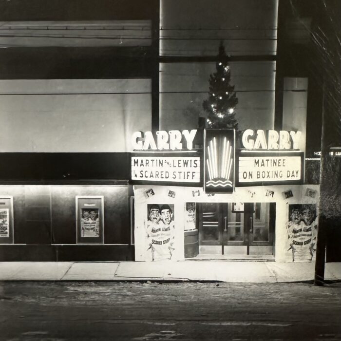 Black and white photo of the Garry signs lit up at night