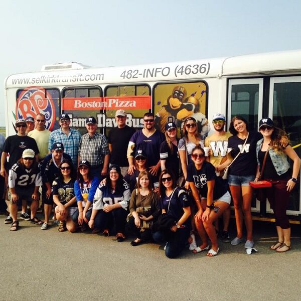 Photo of a group of people gathered around a bus
