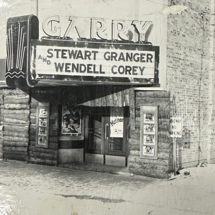 A black and white photo of the entrance to the Garry Theatre. The sign above the door reads 'Stewart Grander Wendell Corey'