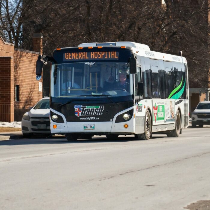 A photo of a bus driving down the road. A white car is in the lane beside the bus