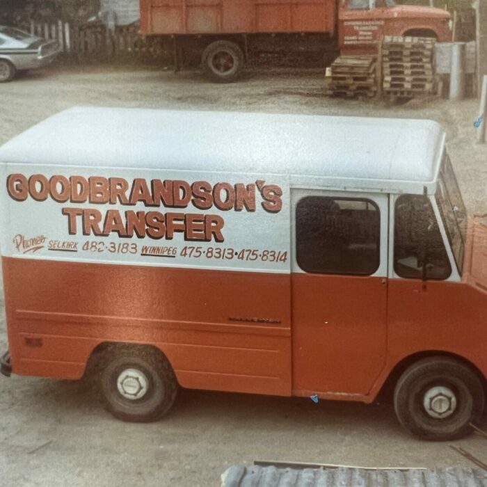 Colour photo of a red and white van with the words 'Goodbrandson's Transfer' on the side