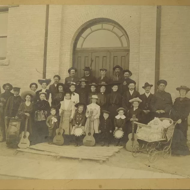 Grandmom Jessi second from the right with the Salvation Army, Date Unknown, Jock Langlois Black and white portrait of a large group holding instruments in front of a building
