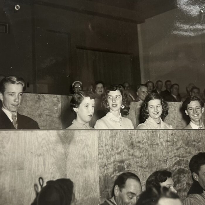 A black and white photo of a group of young men and women sitting in the seats at the Garry Theatre