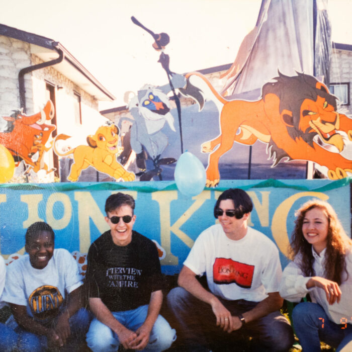 Colour photo of the Lion King parade float. There are five people at the back of the float
