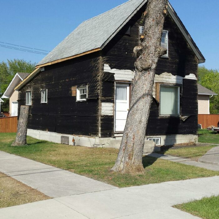 Jack Laye's House before Being Demolished, 2019, Glen Laye Colour photo of a black house. There is a tree in the front yard