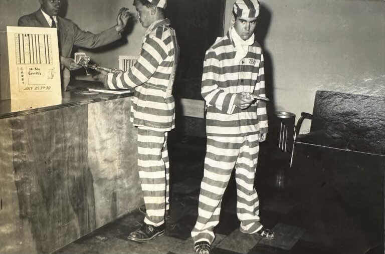 2 men in jail prisoners costumes to promote the Jail House Rock Movie premiering at the Gary Theatre