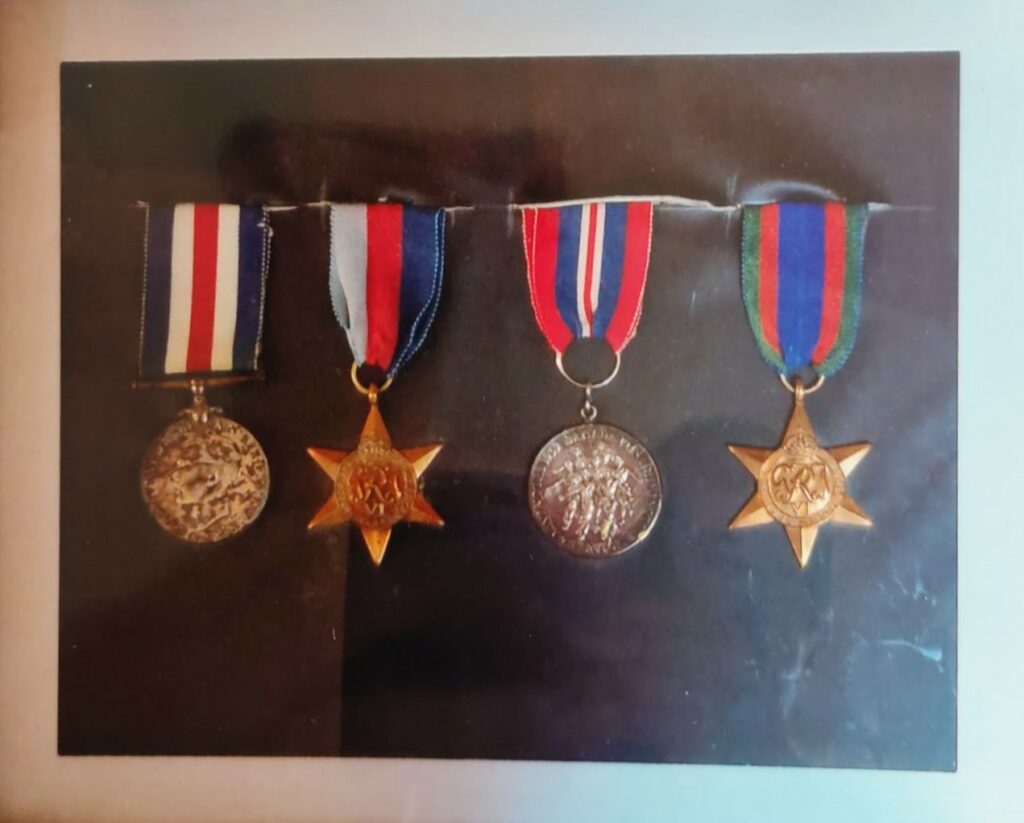 Colour photo of four medals framed on a black background