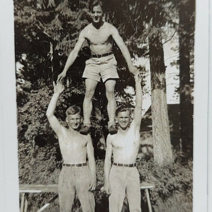 John V. Sinclair and Friends, Date Unknown, Mae Gulewich Black and white photo of a man standing on the shoulders of two other men