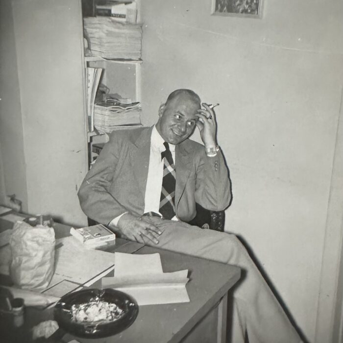 Man relaxing in the Garry Theatre office smoking a cigarette