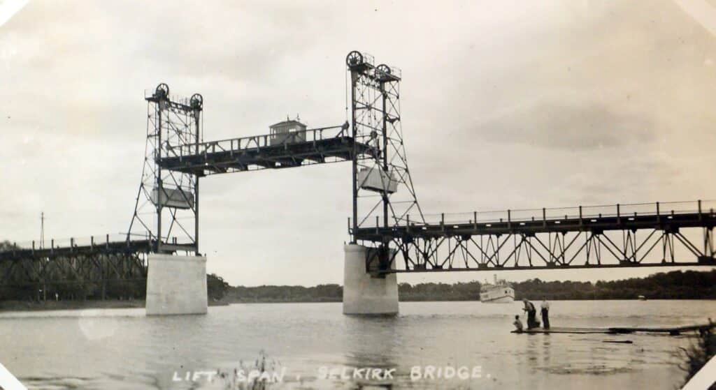 This black and white image shows the Selkirk Lift Bridge raised