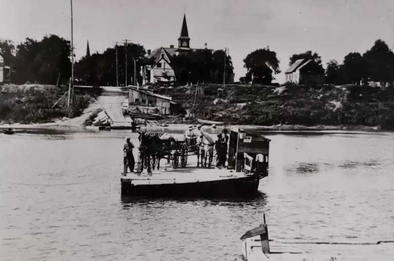 Black and white photograph showing a ferry and Knox church in the background.