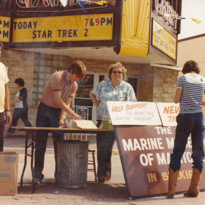 Colour photo of a table for Marine Museum donations in front of the Garry theatre entrance