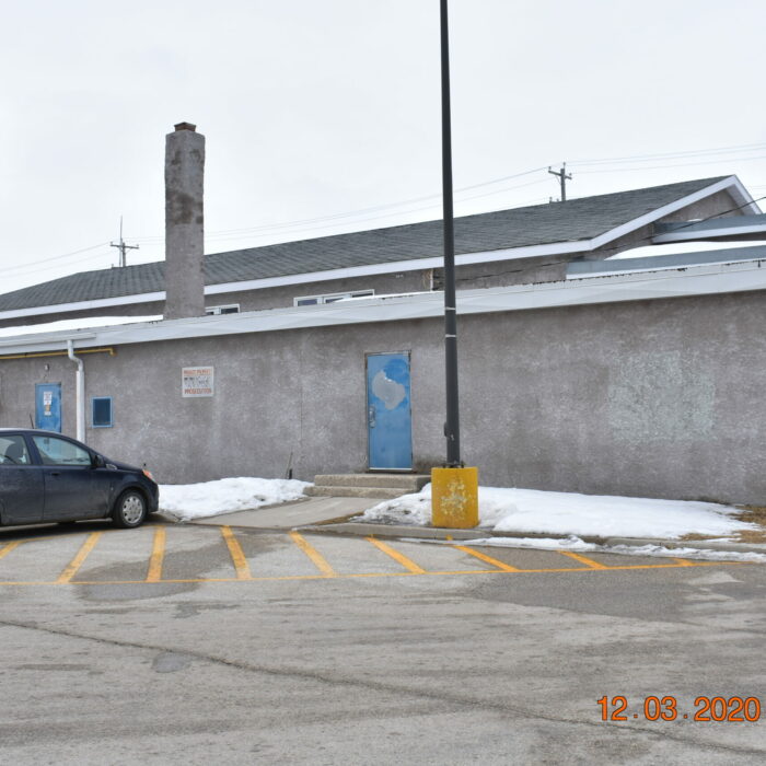 Colour photo of the exterior of memorial hall. The water tower can be seen in the background