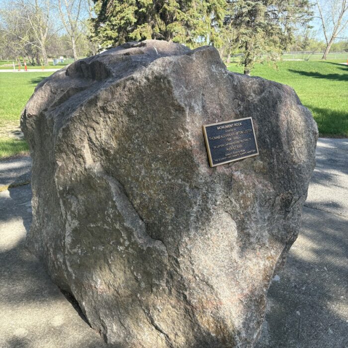 Colour photo of a large rock with a plaque in the center