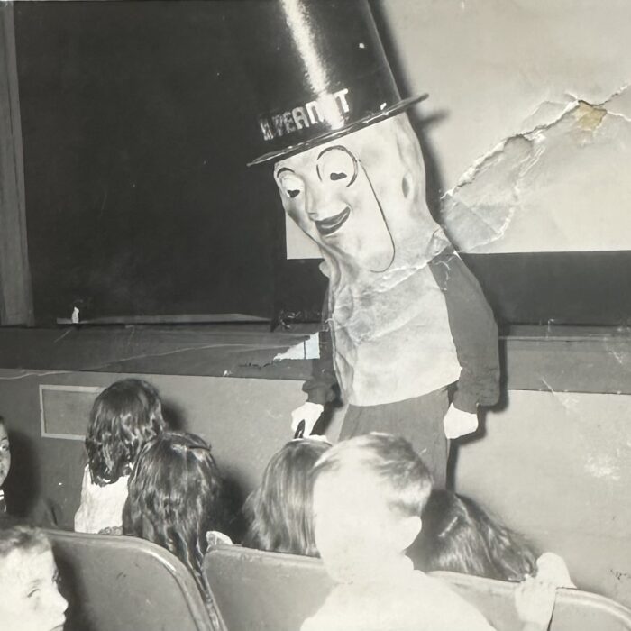 Large Mr. Peanut mascot interacting with children in the front row of the Garry Theatre
