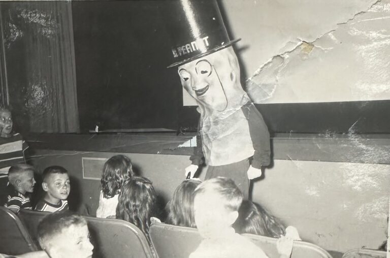 Large Mr. Peanut mascot interacting with children in the front row of the Gary Theatre