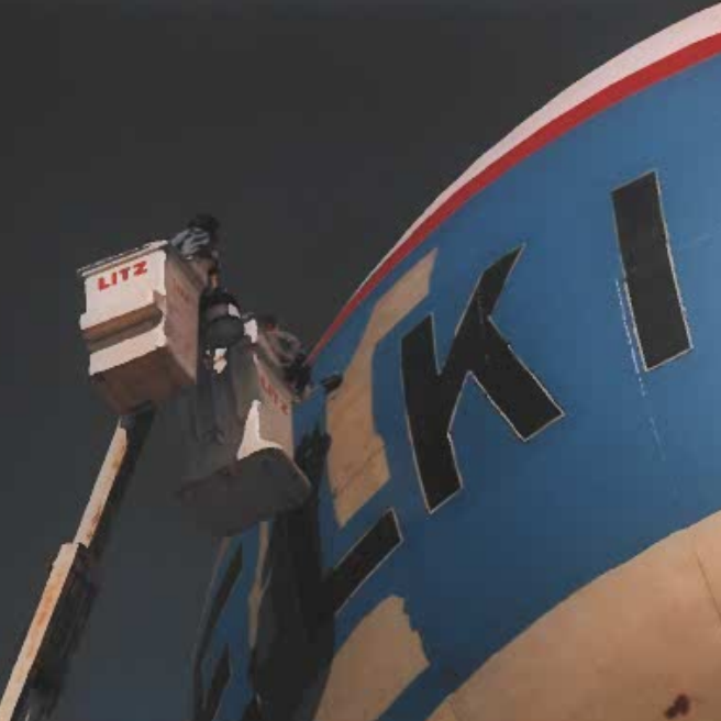 Colour photo of blue paint being added to the Selkirk Water Tower. There is a crane