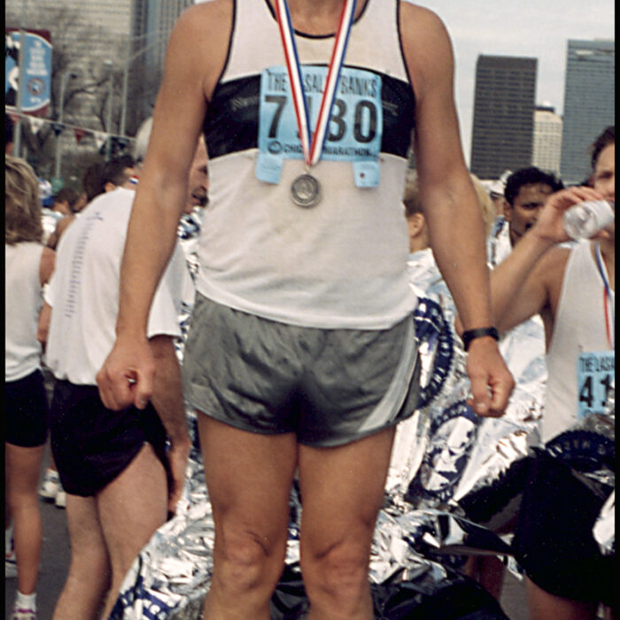 Podruchny at Chicago, 1994, Thomas Podruchny Man is standing with a silver medal around his neck. He is wearing a white and black shirt with grey shorts. He is smiling. The text 'Chicago IL' is printed in the bottom right corner
