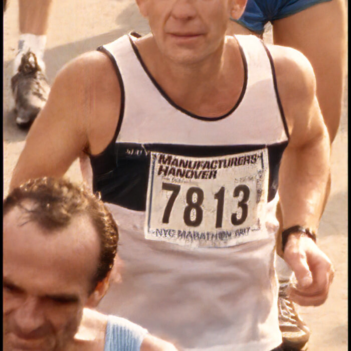 Podruchny at New York City, 1987, Thomas Podruchny Man runs amongst other runners. He is wearing a white shirt and black shorts. The number 7813 is pinned to his shirt