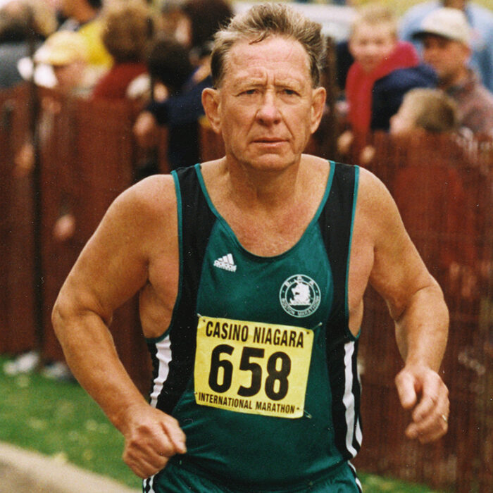 Podruchny at Niagara Falls, 2001, Thomas Podruchny Image of Tom running towards the camera he is wearing a green shirt and green shorts. The number 658 is pinned to his shirt