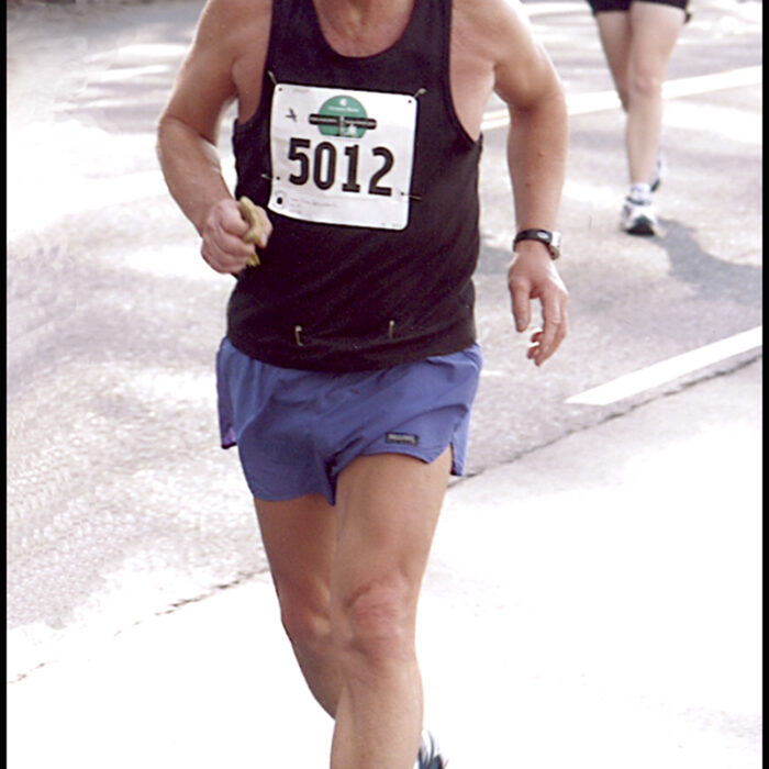 Podruchny at Philadelphia, 2003, Thomas Podruchny Man runs towards camera. He is wearing a black shirt and blue shorts. The number 5012 is pinned to his shirt