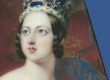 This is a picture of Queen Victoria. She is wearing a gold gown and a red and silver crown. She is pale with brown hair that is short.