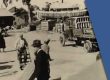 Picture of a busy Robinson Avenue from the 1990s. The road is occupied by a truck moving materials, people walking and biking.