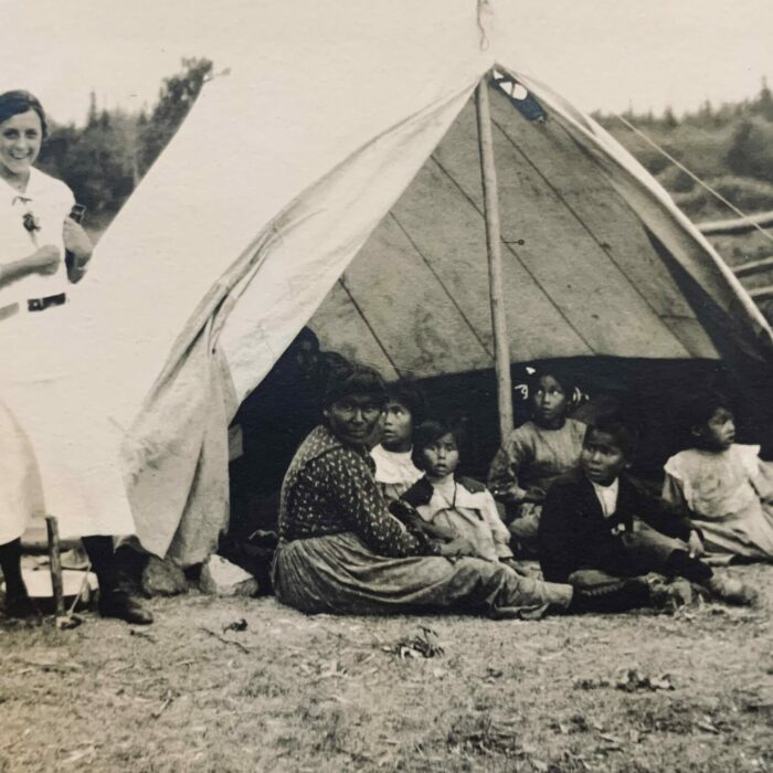 Ruth Hooker Camp Ruth Hooker standing with a man beside a tent that has children inside.