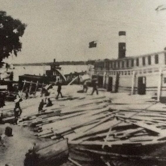 Photo of people unloading logs from on the Selkirk docks in 1910