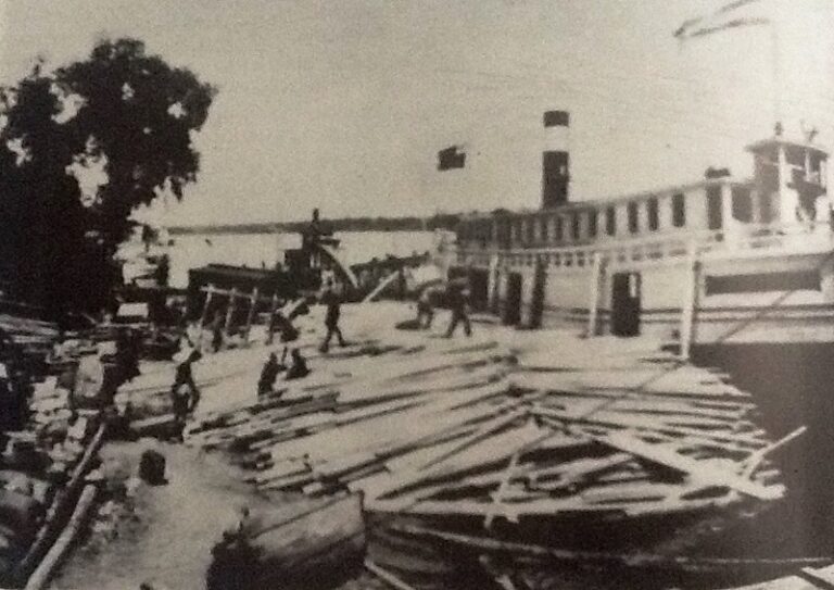 Photo of people unloading logs from on the Selkirk docks in 1910