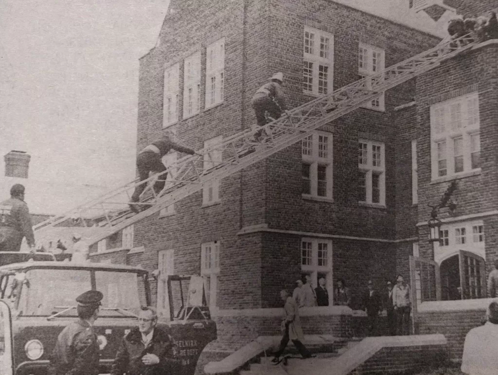 Image showing a fire truck with the ladder extended. Two firemen are climbing the ladder to perform a fire drill at Selkirk Mental Health Centre