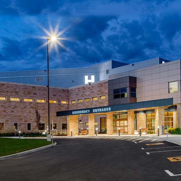 Selkirk Regional Health Centre, 2017, Gerry Kopelow View of new hospital at night. Large parking lot light is central in the photograph. Warm light shines from hospital front doors