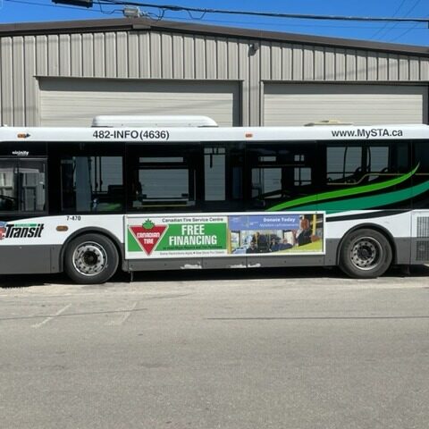 Colour image of a bus parked in front of a two vehicle garage
