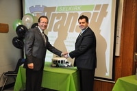 Mayor Larry Johannson and CAO Duane Nicole cutting a Selkirk Transit cake shaped as the Selkirk Transit bus.
