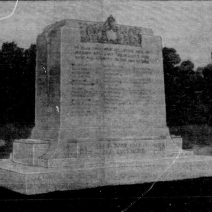 Black and white photo of a large white stone cenotaph in the middle of a grassy clearing