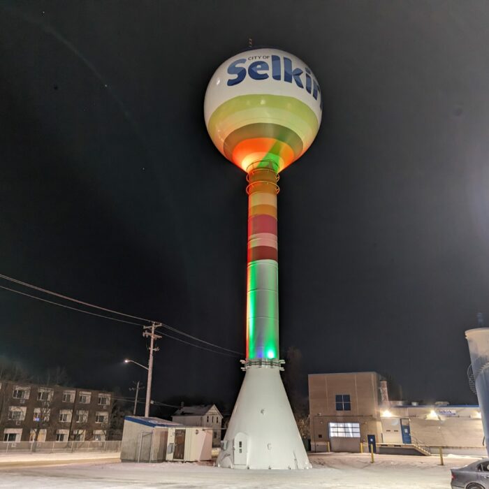 Selkirk water tower with fresh paint job lit up multicoloured at nighttime